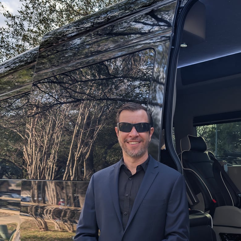Christian Johnston, founder of Drive Top-Line, in a suit beside a luxury Sprinter limo in Austin